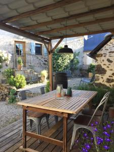 une table et des chaises en bois sur une terrasse en bois dans l'établissement Gîte Maison Maitri, à Forgès