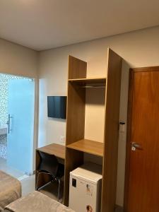 a room with a bed and a desk with a computer at Hotel Cabana in Caetanópolis +25 photos