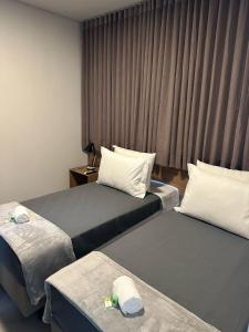 Cette chambre comprend 2 lits et une fenêtre. dans l'établissement Hotel Cabana, à Caetanópolis