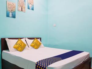 a bedroom with a bed with yellow and blue pillows at OYO Hotel Hanu Inn in Bilāspur