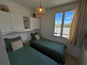 a bedroom with two beds and a window at Maison cosy 4-6 personnes - Village Pierre & Vacances in Grospierres +11 photos