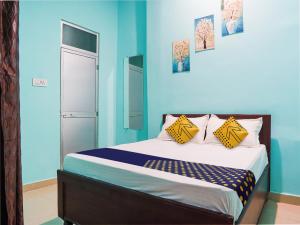 Schlafzimmer mit blauen Wänden und einem Bett mit gelben Kissen in der Unterkunft OYO Hotel Hanu Inn in Bilāspur