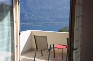 balcone con sedia e sgabello rosso di Villetta 56 Blu Yellow and Red Lake view Garden Private Parking by Garda Domus Mea a Tremosine Sul Garda