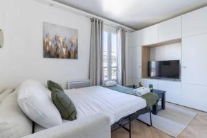 ein Schlafzimmer mit einem Bett, einem Sofa und einem TV in der Unterkunft So Ouest/Courcelles : Magnifique Studio in Levallois-Perret