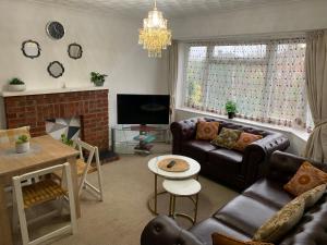 a living room with a couch and a fireplace at Luxury Two Bed Deluxe Maisonette in Wrecclesham