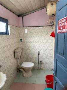 a bathroom with a toilet and a sink at Aranya Darshan in Lataguri +34 photos