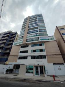 a tall building on a street with at Ivana Imoveis - Grupo de Aptos Temporada - Praia do Morro in Guarapari