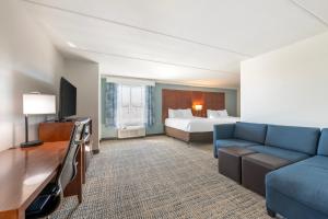 a hotel room with a bed and a couch at Comfort Suites Fernandina Beach at Amelia Island Soon to be Surf & Sand Ascend Collection by Choice in Fernandina Beach