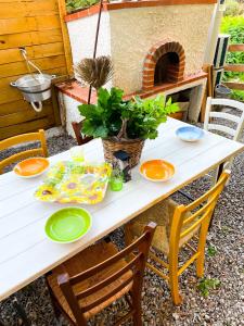 a table with plates and a potted plant on it at Canonica dimore in Cefalù +25 photos