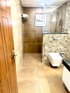 Nandi的住宿－Summer House Nandi Foothills，一间带卫生间和玻璃淋浴间的浴室