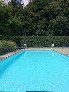 una gran piscina azul con 2 sillas. en North Mundham, Shared Pool, Tennis Court, Zip Wire & Table Tennis! DOG FRIENDLY en North Mundham