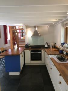 a kitchen with white cabinets and a stove top oven at North Mundham Cottage, Shared Pool, Tennis Court, Zip Wire & Table Tennis! DOG FRIENDLY in North Mundham
