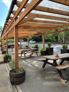 eine Gruppe von Picknicktischen unter einem Holzpavillon in der Unterkunft Royal Oak Appleby in Appleby