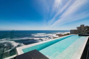 a swimming pool with a view of the ocean at The Aurum Collection by Totalstay in Cape Town