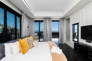 a bedroom with a white bed and large windows at The Aurum Collection by Totalstay in Cape Town