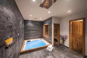 uma banheira de hidromassagem na casa de banho com uma parede de pedra em 3 bedroom chalet Steern by Dieckereise em Verbier