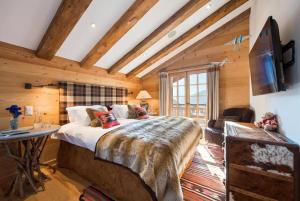 um quarto com uma cama grande num quarto com tectos em madeira em 3 bedroom chalet Steern by Dieckereise em Verbier