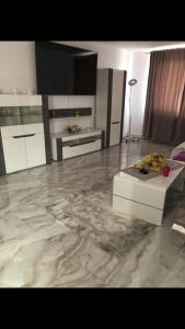 een woonkamer met een marmeren vloer en witte kasten bij Casa Alex in Dîrlos