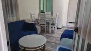 sala de estar con sofá azul, mesa y sillas en Getu furnished apartments at CMC, en Addis Ababa