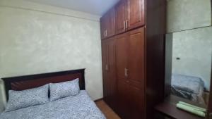 a bedroom with a bed and some wooden cabinets at Getu furnished apartments at CMC in Addis Ababa