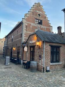 a brick building with a barrel in front of it at De Pelgrim in Tongeren