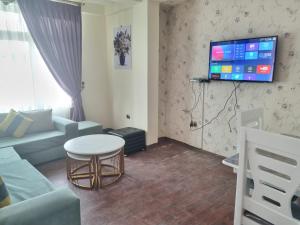 a living room with a couch and a table and a tv at Getu furnished apartments at CMC in Addis Ababa