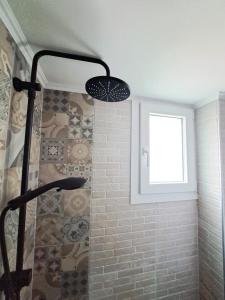 a bathroom with a shower with a window at Stylish City Center Apartment - with FREE PARKING space -not for big cars- 200m away in Serres