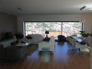 a living room with white furniture and a large window at Vivenda Madalena in Machico