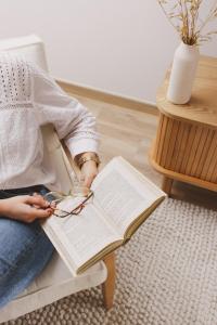 a person sitting on a chair reading a book at Pure Flor de Esteva in Vila do Bispo