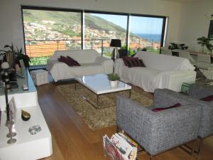 een woonkamer met banken en uitzicht op de stad bij Vivenda Madalena in Machico