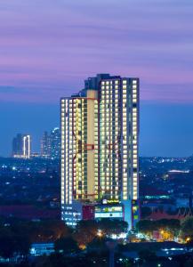 um edifício alto com luzes acesas numa cidade em Best Western Papilio Hotel em Surabaya