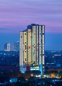 een hoog gebouw met lichten aan in een stad bij Best Western Papilio Hotel in Surabaya