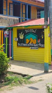 a yellow building with a sign on the side of it at Bastimentos Hill Guest House in Bocas del Toro