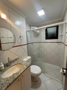 a bathroom with a toilet and a sink and a tv at Apartamento Canto Do Forte - Praia Grande Top in Praia Grande +28 photos