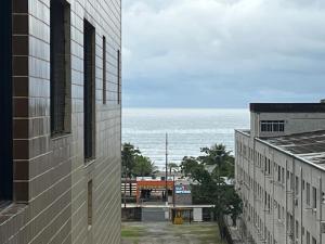 a view of the ocean from between two buildings at Apartamento Canto Do Forte - Praia Grande Top in Praia Grande