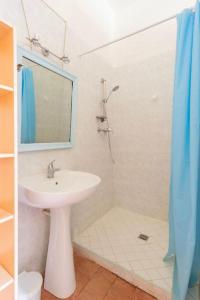 uma casa de banho com um lavatório e um chuveiro com um espelho. em Château Monvallon em Charentay