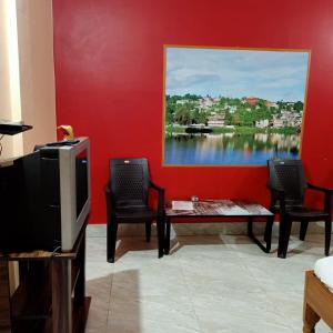 sala de estar con TV, mesa y sillas en Aranya Darshan, en Lataguri
