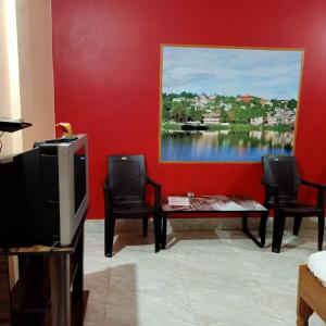 a living room with a tv and a table and chairs at Aranya Darshan in Lataguri