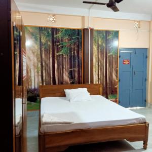 1 dormitorio con 1 cama y una pintura de árboles en Aranya Darshan, en Lataguri