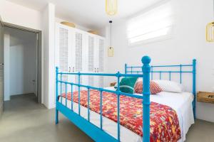 a bedroom with a blue bed with a red blanket at Villa with private pool in Dhriopís