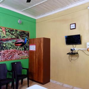a room with a painting of a peacock on the wall at Aranya Darshan in Lataguri