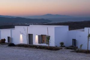 a white building with a sunset in the background at Villa with private pool in Dhriopís