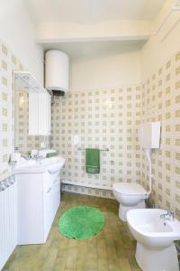 聖費利切德爾貝納科的住宿－Locanda San Felice，一间带两个卫生间的浴室和绿色地毯