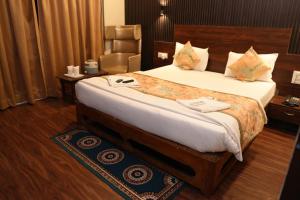 伯杰默里Hotel Indraprastha pachmarhi的一间带床和椅子的酒店房间