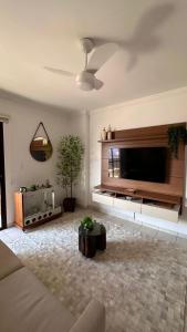 a living room with a large flat screen tv at Apto Lindo e Completo Beira Mar - Vila Caiçara in Solemar