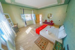 una camera da letto con un letto con una coperta rossa sopra di Villa Coup De Cœur a Marrakech