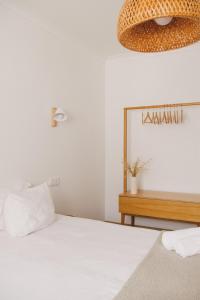 a bedroom with a bed and a chandelier at Pure Flor de Esteva in Vila do Bispo