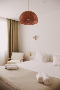 - une chambre avec un lit et des serviettes dans l'établissement Pure Flor de Esteva, à Vila do Bispo