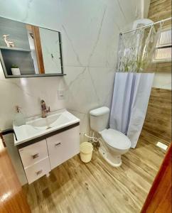 een badkamer met een toilet, een wastafel en een spiegel bij Apartamentos - Estúdios in São José