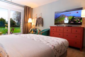 a bedroom with a bed and a flat screen tv at gite du vieux saule et spa in Vieil-Hesdin